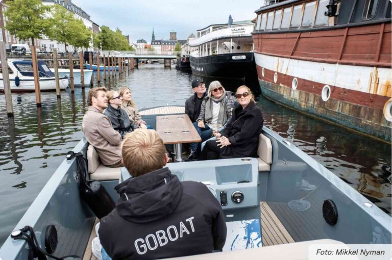 Kanalrundfart med go boat med mennesker i båden på den guidede sejltur i københavn